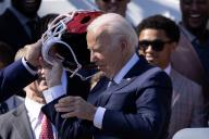 US President Joe Biden takes off a Kansas City Chiefs helmet during a ceremony welcoming the Kansas City Chiefs to the White House to celebrate their championship season and victory in Super Bowl LVIII, on the South Lawn of the White House in Washington, DC, USA, 31 May 2024