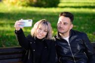 Two young friends in a park taking a selfie with the mobile