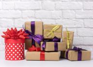 stack of various gift boxes on white brick background, festive backdrop