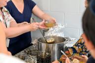 Unrecognizable people serve in soup kitchen, food kitchen, or meal center, a place where food is offered to the hungry usually for free or sometimes at a below-market price