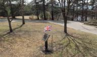 Needham, Massachusetts USA: April 12, 2014 Plaque and Union Jack flag honor two British airmen who died from an airplane crash near this spot during World War II, on June 6, 1944. Their names were Lt. Albert Dawson and First Class Stanley C. Wells. ...