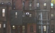 Boston, Massachusetts USA October 9, 2014 A basketball hoop is situated on a third floor balcony of a five story residential building. These buildings, seen from their rear sides within an ally, are brownstones. The front sides are located on ...