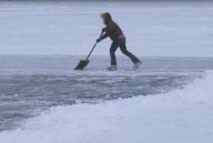 Millis, Massachusetts USA January 11, 2015 Skater clears snow at Richardson