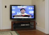 Millis, Massachusetts USA 01-22-2015 Live press conference with Tom Brady, quarterback for the New England Patriots, appears on a television in a living room. Brady denied knowledge of footballs being deflated during a rainy AFC championship game. ...