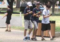 Franklin, MA USA: July 15, 2016 Boys and a young man (at left) play the virtual game, Pokmon Go, at a town common. Chris Fitzgerald / Candidate Photos