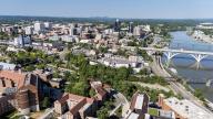 An aerial view of Knoxville, Tennessee reveals a vibrant cityscape with a mix of historic and modern buildings, the Tennessee River weaving through downtown, lush green parks, and the distant Smoky Mountains framing the horizon.(Credit Image: Â Walter G Arce Sr Grindstone Medi\/Cal Sport Media