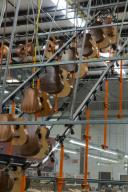 Guitar bodies are placed on an automated carousel running around the ceiling of the factory to save storage space while the newly glued bridges dry in the Taylor Guitar factory in Tecate, Mexico