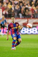 Xavi Hernandez executes a strategic pass in a high-stakes match between Sevilla and Barcelona