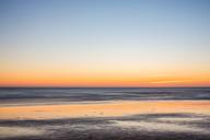Post-sunset glow with smooth waters at Palmar Beach, Vejer