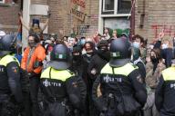 Dutch anti-riot police break through barricades set by students pro-Palestinian protest against the ongoing conflict Israel and the Palestinian at the University of Amsterdam on May 8, 2023 in Amsterdam,Netherlands