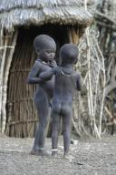 zwei Toposa-Kinder stehen vor Huette, Sudan | two Toposa children standing in front of a hut,