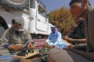 Maenner bei der Essenszubereitung vor einem Auto, Aegypten, Weisse Wueste Nationalpark | men preparing the meal in front of a car, Egypt, White Desert National