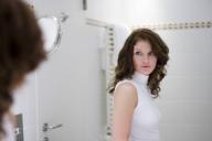 Spiegelbild einer jungen attraktiven Frau im Badezimmer | mirror image of a young, pretty woman in the