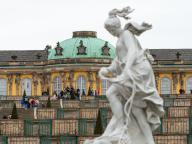 29 March 2024, Brandenburg, Potsdam: Strollers walk along the steps through the vineyard terraces against the backdrop of Sanssouci Palace. The Prussian Palaces and Gardens Foundation starts the new season today. Photo: Georg-Friedrich Moritz\/dpa