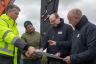 19 April 2024, Lower Saxony, Harlesiel: Thomas Schoneboom, Head of Planning and Construction at NLWKN, Member of the State Parliament Sina Beckmann, Lower Saxony\'s Environment Minister Christian Meyer (both Greens) and Frank Thorenz, Head of the NLWKN\'s Norden branch (l-r), look at a plan together on a coastal protection construction site. Together with the federal government, Lower Saxony plans to invest around 80 million euros in coastal protection on its mainland and islands this year. (to dpa: "New sand for islands - Lower Saxony invests in coastal protection") Photo: Lennart Stock\/dpa
