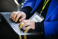 Symbolic photo on the subject of journalism: A journalist is typing on the keyboard of her laptop and is wearing an accreditation with the inscription \u0082Äô Press \u0082Äô. Berlin, April 26, 2024