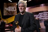 03 May 2024, Berlín;: Director Matthias Glasner holds the Lola d\'Or German Film Award for his film "Sterben" (Dying). Photo: Sebastian Christoph Gollnow\/dpa