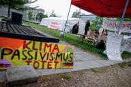 07 May 2024, Berlin: A sign with the text "Climate passivism kills" stands at the entrance to a camp and a banner with the text "Solidarity with the hunger strike for climate justice" from the alliance "Starve until you are honest" in Invalidenpark. Photo: Carsten Koall\/dpa