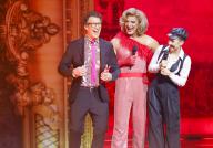 10 May 2024, North Rhine-Westphalia, Cologne: Daniel Hartwich (l-r), presenter, Detlef D! Soost, coach, and Ekaterina Leonova, professional dancer, stand in the wings of the musical "Moulin Rouge!" in the RTL dance show "Let