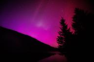 11 May 2024, Bavaria, Krün: Northern lights (aurora borealis) shine in the night sky above Lake Wagenbrüchsee. Photo: Matthias Balk/dpa
