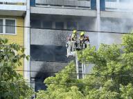 11 May 2024, Berlin: Firefighters stand on a turntable ladder during an operation. People have been injured in an apartment fire in a ten-storey tower block in Berlin. Photo: Sappeck/BLP/dpa