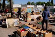 21 April 2024, Berlin: 21.04.2024, Berlin. People walk through the flea market at Mauerpark. At one stand, all kinds of items are for sale in cardboard boxes. Photo: Wolfram Steinberg/dpa Photo: Wolfram Steinberg/dpa