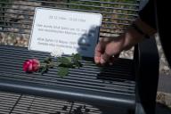 12 May 2024, Berlin: A woman places a rose in front of a sign with the date of birth and death and the sentence "Ufuk ·ahin was murdered here on May 12, 1989 for racist motives" during a memorial service for Ufuk ·ahin under the motto "We commemorate Ufuk ·ahin - Murdered by a racist 35 years ago, on May 12, 1989, in Reinickendorf-Wittenau". ·ahin was fatally injured in a knife attack 35 years ago. Photo: Sebastian Christoph Gollnow/dpa