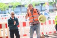 13 May 2024, Lower Saxony, Langenhagen: Kai Schwabe (r), Regional Head of IG BAU, and Mehrdad Payandeh, District Chairman of the DGB, speak during a warning strike by employees in the construction industry at a pipeline construction site in the Hanover region. According to the union, strikes in the construction industry, which employs 930,000 people, are to take place selectively throughout Germany from Tuesday. The employers rejected the arbitrator