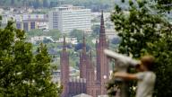 13 May 2024, Hesse, Wiesbaden: A boy looks at the neo-Gothic Marktkirche from the Neroberg with a telescope. Photo: Andreas Arnold/dpa