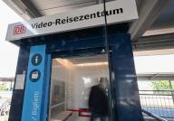 PRODUCTION - 13 May 2024, Baden-Württemberg, Winnenden: A person stands in a video travel center at a regional train station and receives personal advice via video (staged scene). If you want to buy a train ticket in Baden-Württemberg, you can use Deutsche Bahn (DB) video travel centers at 55 locations. DB employees advise customers in a similar way to a travel center - only via screens in a video call. Connection information and tickets are printed out immediately. Photo: Bernd Weißbrod/dpa