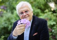 13 May 2024, Hamburg: Justus Frantz, conductor, smells a flower during a photo session in his garden before the book launch of his biography. The biography ""Justus Frantz - Künstler zwischen den Welten"", written by Jens Meyer-Odewald, will be published by Maximilian Verlag on May 18 to mark Frantz