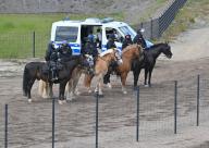 11 May 2024, Brandenburg, Grünheide: Mounted police officers stand with their horses on the Tesla factory premises. Photo: Patrick Pleul/dpa