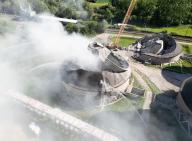 14 May 2024, Hesse, Großkrotzenburg: A cooling tower is demolished on the site of the Staudinger coal-fired power plant in Großkrotzenburg and collapses in a cloud of dust (aerial view with a drone). However, the power plant itself remains as an emergency reserve. Photo: Boris Roessler/dpa