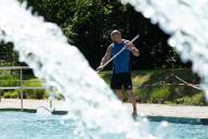 14 May 2024, Saxony, Dresden: Robert Reinsberger uses a landing net to clean a pool at the Kombibad Prohlis. Three outdoor pools in Dresden will open on May 16, 2024 for the outdoor pool season, which runs until September 6, 2024. Photo: Sebastian Kahnert/dpa