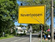 14 May 2024, North Rhine-Westphalia, Leverkusen: RECROP - The sign at the entrance to the town of Leverkusen in the Schlebusch district has been covered with the words "Neverloosen" in reference to the winning streak of Bundesliga soccer team Bayer 04 Leverkusen. Photo: Holger Schmidt/dpa
