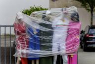 15 May 2024, Hesse, Frankfurt/Main: A retailer has protected his display mannequins against rain showers with plastic bags. Photo: Andreas Arnold/dpa
