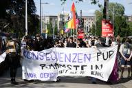 15 May 2024, Saxony, Dresden: Demonstrators stand on Jorge Gomondai Square during a rally and hold a banner reading "Consequences for Rammstein - in court instead of on stage". The occasion is the concerts by the German band Rammstein in Dresden. Photo: Sebastian Kahnert/dpa