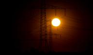 16 May 2024, Saxony, Böhlen: The sun rises behind overhead power lines near Böhlen. After a sunny start to the week, the weather becomes more changeable at Whitsun. Photo: Hendrik Schmidt/dpa