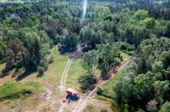 16 May 2024, Mecklenburg-Western Pomerania, Lübtheen: A fire engine stands near the extinguished fire on the former military training area. (Aerial photo taken with a drone) A fire broke out on the evening of 15.05.2024, firefighters were able to fight the approximately three-hectare fire. In the summer of 2019, munitions that had been exposed over the years presumably ignited themselves and caused a fire that engulfed almost 1,000 hectares of forest. Photo: Jens Büttner/dpa