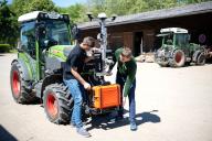 PRODUCTION - 14 May 2024, Lower Saxony, Jork: David Berschauer (left) and Moritz Hentzchel attach the technology from the "SAMSON" project ("Smart automation systems and services for fruit growing on the Lower Elbe") to a tractor. With the help of artificial intelligence, a research project in the Altes Land region near Hamburg aims to make fruit growing more efficient. The aim is to better detect pests and use fewer chemicals. Photo: Sina Schuldt/dpa