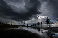 16 May 2024, Bavaria, Kaufbeuren: Thick rain clouds are reflected in a puddle. Photo: Karl-Josef Hildenbrand/dpa