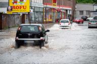 17 May 2024, Saarland, Saarbrücken: Motorists drive through the rising floodwaters on Fischbachstrasse despite the flooding. Photo: Harald Tittel/dpa
