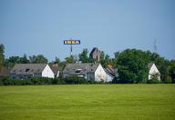 13 May 2024, Brandenburg, Waltersdorf: White apartment buildings stand on the outskirts of the city against the backdrop of the IKEA furniture store logo. Photo: Soeren Stache/dpa
