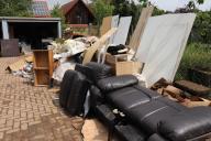 19 May 2024, Saarland, Hornbach: Furniture, swollen doors and other household items are piled up in the courtyard of a house after storms. Continuous rain and flooding have hit the southwest hard. The extent of the damage is still unclear. Photo: Christian Wiediger/dpa