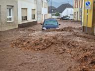 19 May 2024, Rhineland-Palatinate, Kirn: A car makes its way through the masses of water. Extremely heavy rain caused flooding and landslides in the Rhineland-Palatinate town of Kirn on Sunday afternoon. Photo: Sebastian Schmitt/dpa