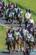 20 May 2024, Bavaria, Bad Kötzting: Participants in the Kötztinger Pfingstritt ride their horses along a road. The procession is one of the oldest Bavarian traditional events. The "men