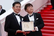 Goro Miyazaki and Kenichi Yoda pose with the Golden Palm for Studio Ghibli during the 77th Cannes Film Festival at Palais des Festivals in Cannes, France, on 20 May 2024