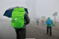 22 May 2024, Saxony-Anhalt, Schierke: A hiker on the Brocken with an umbrella. Stormy weather surprised a group of hikers on the Brocken in the early morning. It will remain unstable in the coming days. Photo: Matthias Bein/dpa
