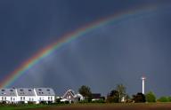 22 May 2024, Bavaria, Kaufbeuren: A rainbow stretches over houses and farmland. Photo: Karl-Josef Hildenbrand/dpa