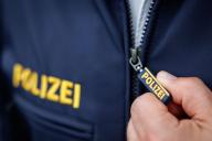 22 May 2024, Bavaria, Nuremberg: The word "Police" is written on the zipper puller and the jacket of a police officer. Photo: Daniel Karmann/dpa